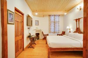 a bedroom with a bed and a desk in a room at Danish Villa Heritage Property in Shimla