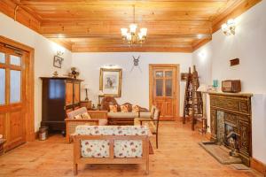a living room filled with furniture and a fireplace at Danish Villa Heritage Property in Shimla