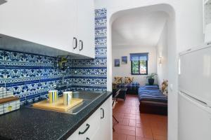 a kitchen with blue and white tiles on the wall at T0 Pedras Del Rei in São Pedro