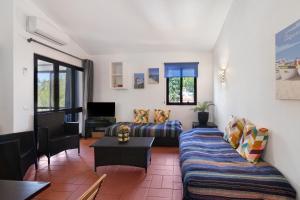 a living room with a couch and a table at T0 Pedras Del Rei in São Pedro