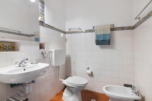 a bathroom with a white toilet and a sink at T0 Pedras Del Rei in São Pedro +14 photos
