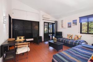 a living room with a couch and a table at T0 Pedras Del Rei in São Pedro