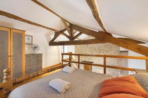 a bedroom with a bed in a room with beams at Gîte des Fraignaies in Saint-Juire-Champgillon +13 photos