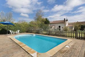 a swimming pool with a table and an umbrella at Gîte des Fraignaies in Saint-Juire-Champgillon