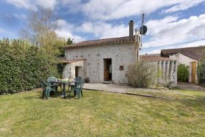 a house with a table and chairs in the yard at Gîte des Fraignaies in Saint-Juire-Champgillon