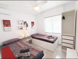 two beds in a white room with a window at R-15 Large Holiday House in Torrevieja +24 photos