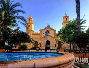 a large church with a large pool in front of it at R-15 Large Holiday House in Torrevieja