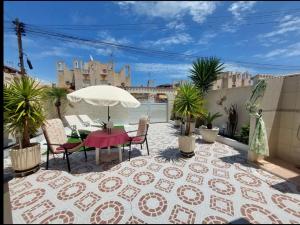 a patio with a table and chairs and an umbrella at R-15 Large Holiday House in Torrevieja