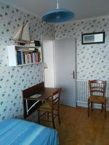 a bedroom with a bed and a table and chairs at Maison Gwel Kaer in Perros-Guirec