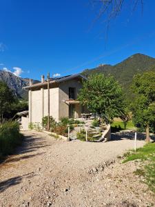 a house on a dirt road with mountains in the background at Casa Meg in Tremosine Sul Garda