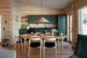 a dining room with a table and chairs in a kitchen at Aurora Atelier Onnela in Rovaniemi