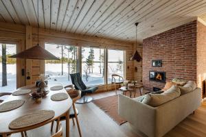 a living room with a table and a brick wall at Aurora Atelier Onnela in Rovaniemi