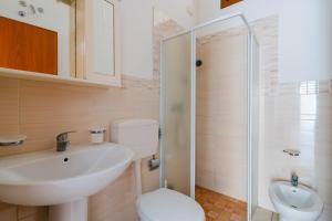 a bathroom with a sink and a toilet and a shower at La casetta 462 in Torre San Giovanni Ugento +14 photos
