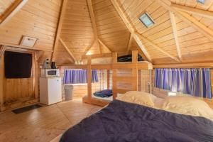 a bedroom with a bed in a wooden cabin at Kota Crème Catalane in Saint-André