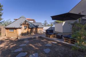a log cabin with an umbrella and a patio at Kota Crème Catalane in Saint-André