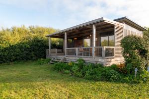 a small house with a porch on a grass field at Chalet 30m2 - Ouessant in Plouhinec