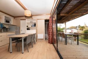 a kitchen and dining room with a table and chairs at Chalet 30m2 - Ouessant in Plouhinec +14 photos