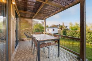 a patio with a table and chairs on a deck at Chalet 30m2 - Ouessant in Plouhinec