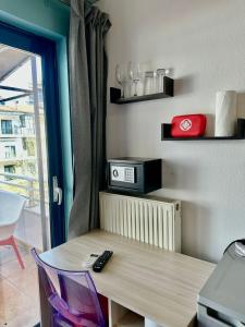 a room with a table and a microwave on a wall at Petit City in Orestiada