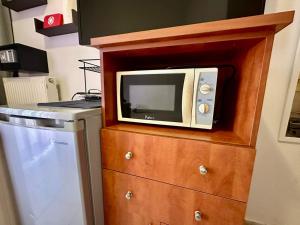 a microwave sitting on top of a wooden dresser at Petit City in Orestiada