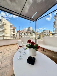 a table with wine glasses and a flower on a balcony at Petit City in Orestiada