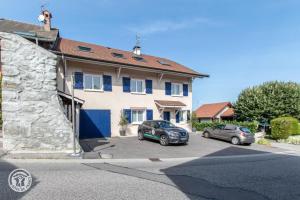 two cars parked in a parking lot in front of a house at Notre Petit Paradis in Annecy
