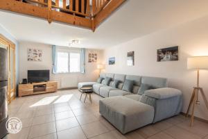 a living room with a couch and a tv at Notre Petit Paradis in Annecy