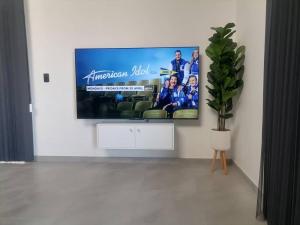 a flat screen tv on a wall in a living room at EHH Accommodation Hentiesbay in Hentiesbaai
