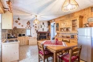 a kitchen with a wooden table and a refrigerator at Baita Bocheto in Levico Terme