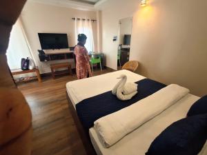 a woman standing in a room with two beds at D9 Restaurant and Hotel in Khetri