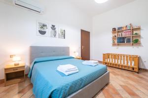 a bedroom with a blue bed and a book shelf at Su Suergiu in San Giovanni Suergiu