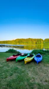 a group of kayaks lined up next to a body of water at Ośrodek Rekreacyjno-Wypoczynkowy Żuczek, Debrzno in Debrzno