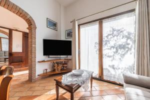 a living room with a large window and a tv at Su Suergiu in San Giovanni Suergiu