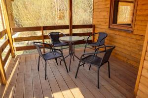 a table and chairs on a porch of a cabin at Ośrodek Rekreacyjno-Wypoczynkowy Żuczek, Debrzno in Debrzno