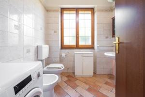 a bathroom with a toilet and a sink and a window at Su Suergiu in San Giovanni Suergiu +20 photos