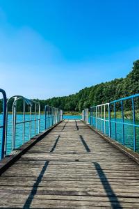 a wooden bridge over a body of water at Ośrodek Rekreacyjno-Wypoczynkowy Żuczek, Debrzno in Debrzno