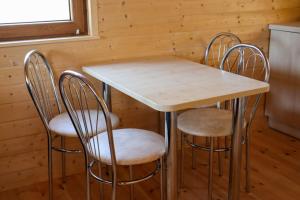a wooden table with four chairs in a kitchen at Ośrodek Rekreacyjno-Wypoczynkowy Żuczek, Debrzno in Debrzno