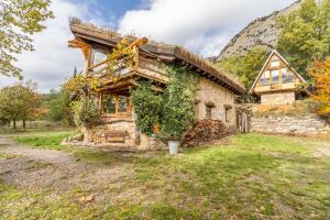 ein altes Steinhaus, das mit Efeu bewachsen ist in der Unterkunft Cal Serrat in Abella de la Conca