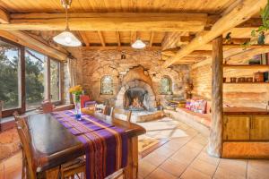 ein Esszimmer mit einem Steinkamin und einem Tisch in der Unterkunft Cal Serrat in Abella de la Conca