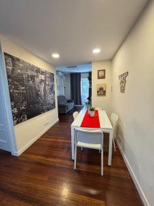 a dining room with a white table and chairs at Apartamento Villarias in Bilbao