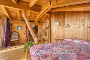 ein Schlafzimmer mit Holzwänden, einem Bett und einem Stuhl in der Unterkunft Cal Serrat in Abella de la Conca