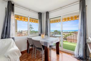a dining room with a table and some windows at Apartamento Segur Calafell in Calafell