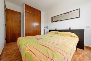 a bedroom with a large bed with a colorful blanket at Apartamento Segur Calafell in Calafell +18 photos