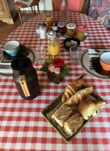 a table with a plate of bread and orange juice at Chambre D'hôtes - Chambre in Jeufosse