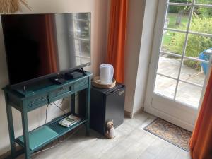 a room with a tv on a stand next to a door at Chambre D'hôtes - Chambre in Jeufosse
