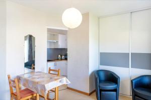 a dining room and kitchen with a table and chairs at Les Mimosas - Appartement 09 in Cazaubon