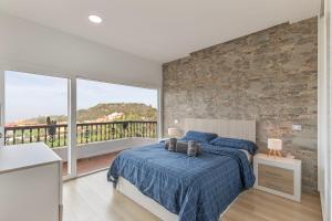 a bedroom with a bed and a stone wall at Teror Hills in Teror +23 photos
