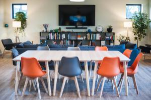 a table and chairs in a room with a couch at Les Hauts De Font Moure in Saint-Georges-des-Agoûts