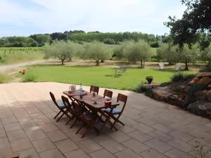 a wooden table and chairs on a patio at Le Gîte du Petit Verdot in Béziers