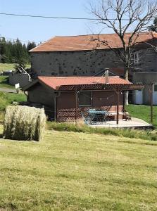 a house with hay bales in front of it at Gîte à la ferme- Chalet à la nuitée in Mazan-lʼAbbaye